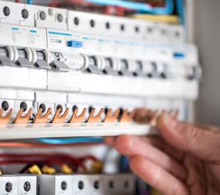 man electrical technician working switchboard with fuses installation connection electrical equipment close up