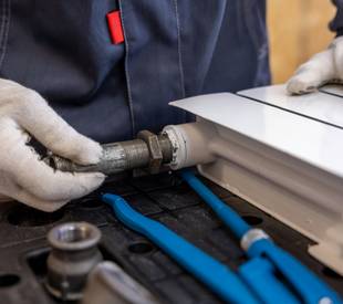 man repairing radiator heating
