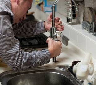 man fixing a kitchen tap
